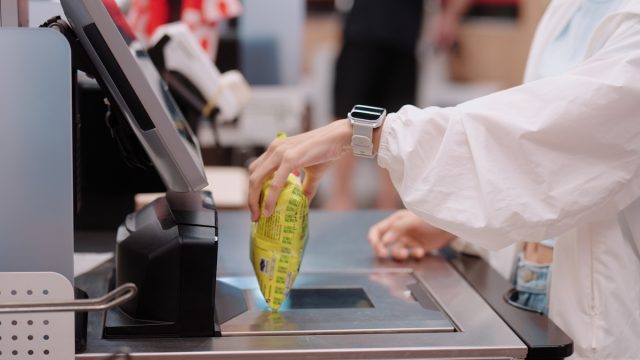 closeup of a female shopper using a self-checkout machine