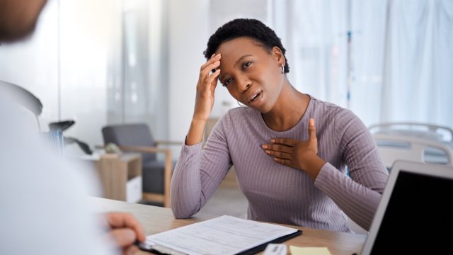 woman having chest pain talking to her doctor
